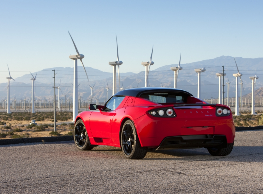 Tesla Roadster in front of wind turbines