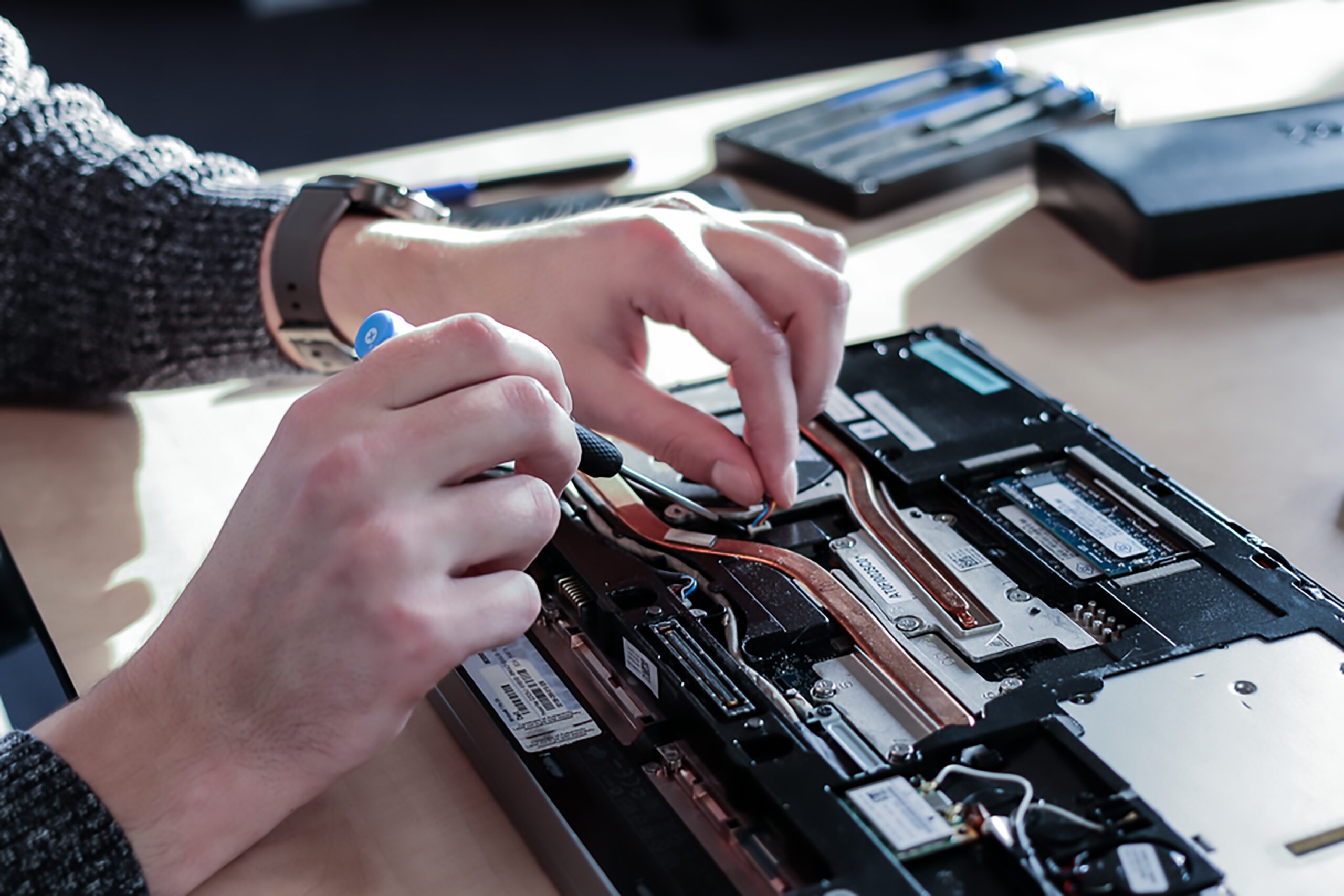 A laptop being repaired with iFixit tools
